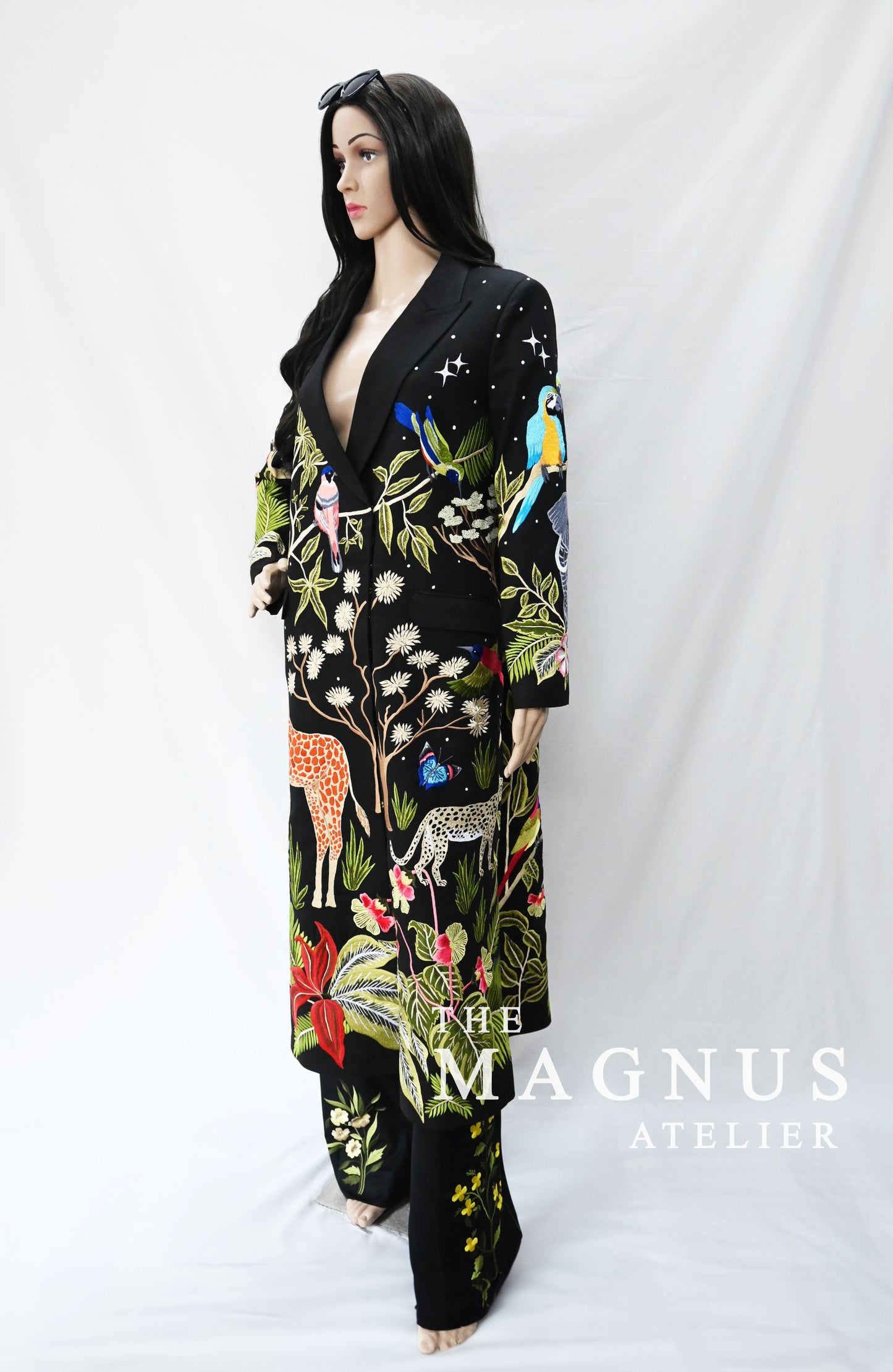 Close-up of detailed embroidery featuring animals and tropical plants on black blazer set