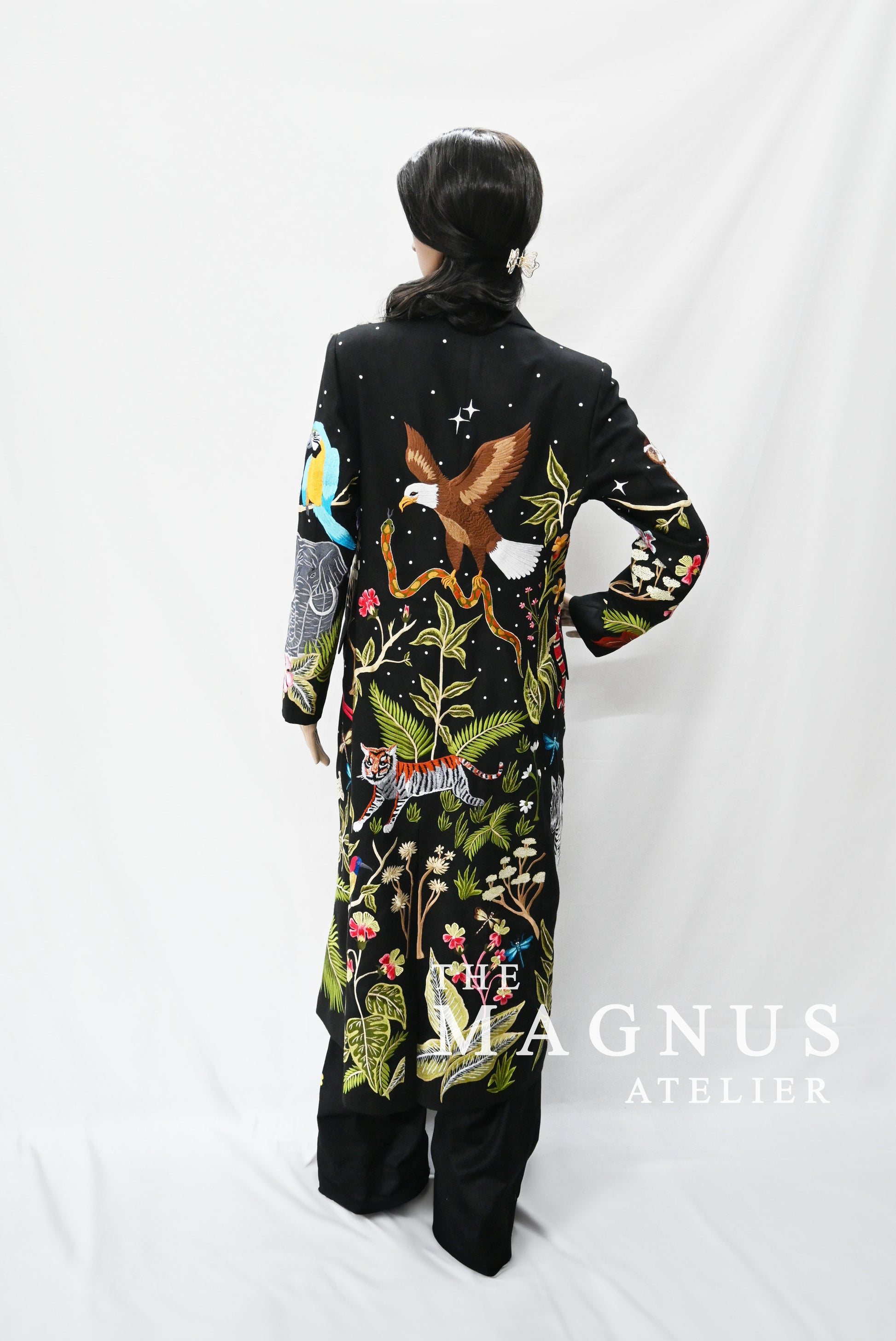 Model wearing black jungle embroidered blazer and matching pants with colorful detailing
