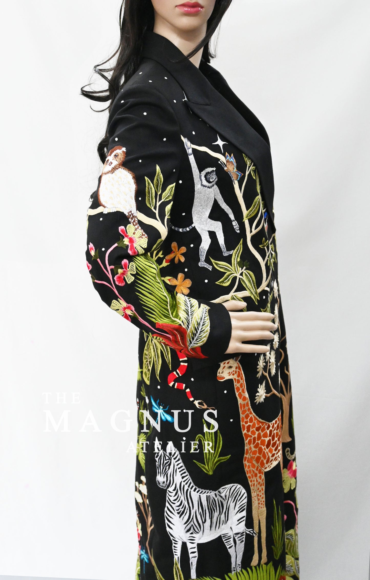 Close-up of detailed embroidery featuring animals and tropical plants on black blazer set